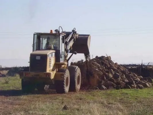 Escribano Obras y Servicios maquinaria recogiendo tierra